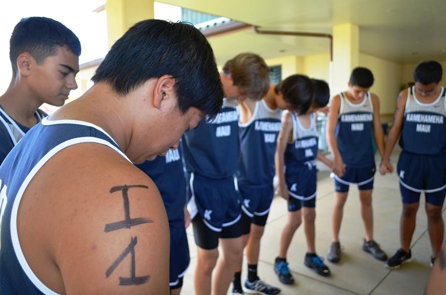 Tevin Tam says a prayer for the boys cross country team before their race on September 1, 2012 at Kamehameha Schools Maui. 