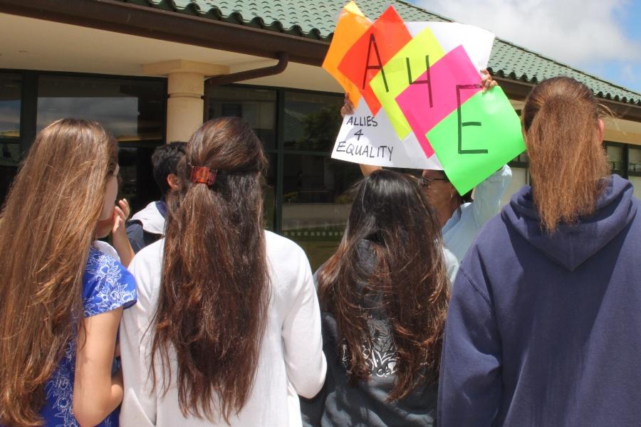 Aunty Venus Rosete-Mederios holds a sign above the crowd to advertise a new club, Allies for Equality, as students gather in front of the counseling center on August 28, 2013.