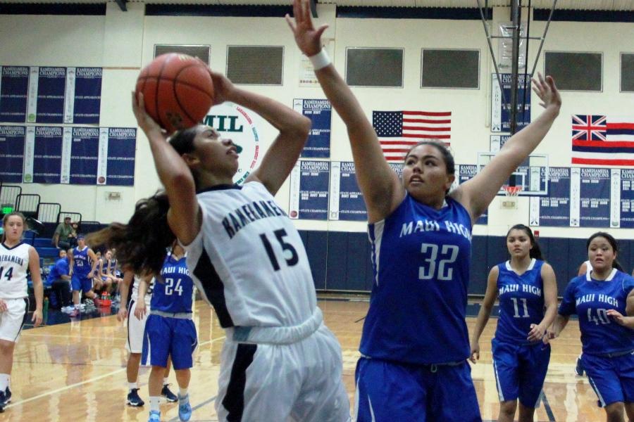 Senior Cheyenne Maio-Silva shoots, December 14, as Nicole Pagan-Eldredge, 32 for the Sabers, attempts to block at Kaʻulaheanuiokamoku. The Sabers won, 53-40, and brought home their first win for the season.