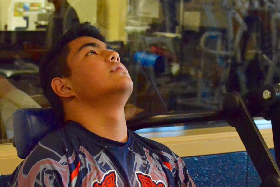 Jarin Correa does neck-strengthening exercises in the weight room before practice.