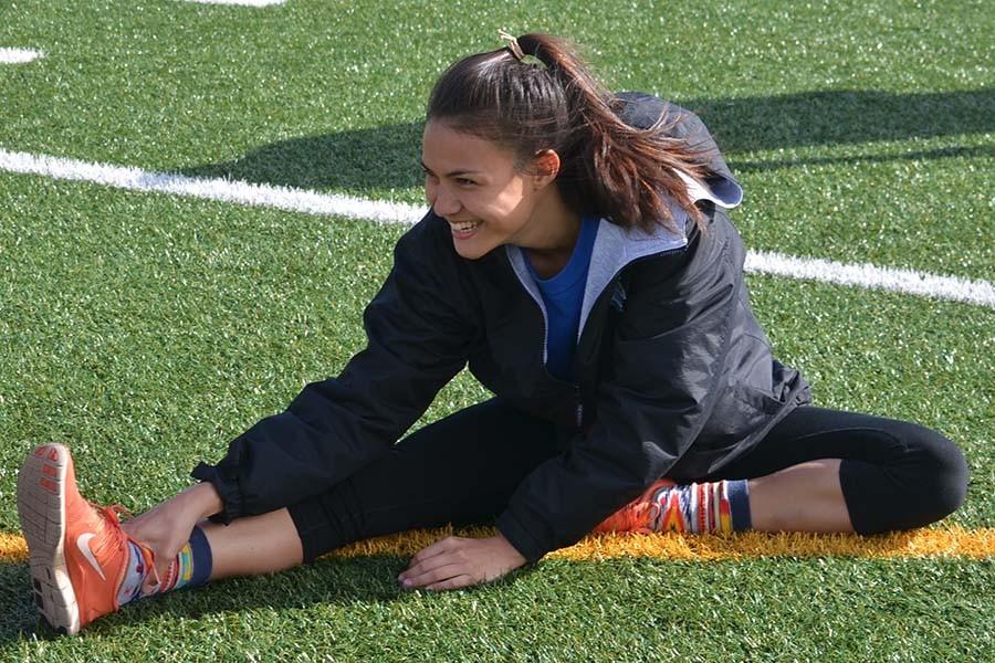 Senior Hannah Patrick stretches with her team before track practice. She has placed at or near the top in triple jump in the first three track meets of the year.