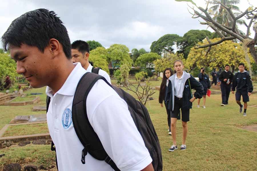 Sophomore Dane Abarra walks through the cemetery at Waiola Congregational Church on the trip to Lahaina with other Hawaiian classes.