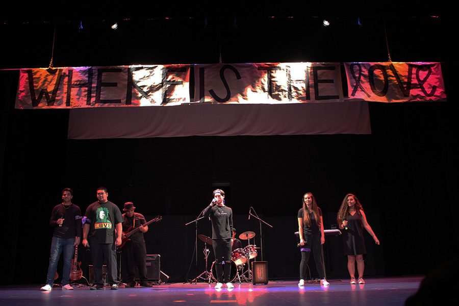 The+junior+band+sing+Where+is+the+Love+while+a+banner+slowly+descends+from+the+ceiling.+Their+performance+was+one+of+six+at+the+Monday+assembly+that+kicked+off+the+2017+Spring+Spirit+Week.