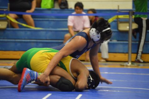 Sophomore Noa Helm holds his opponent down.