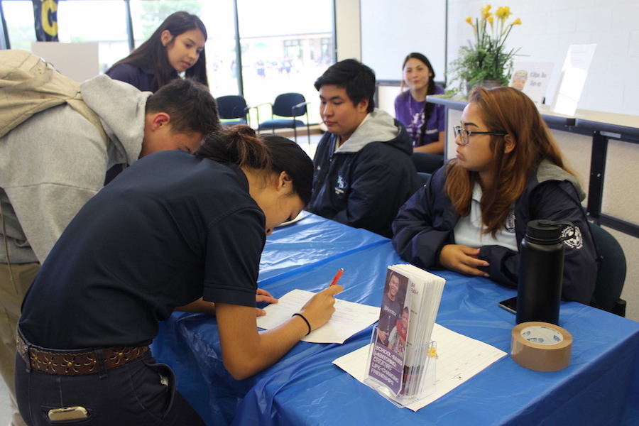 Seniors Makamae Aquino and Dylan Falces sign up volunteers for the Big Brothers Big Sisters after-school program.