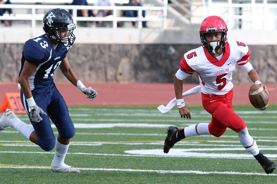 Luna Jesse Dudoit makes a run with Warrior Dayven Tonu trying to follow. The junior varsity Lunas triumphed over the Kamehameha Maui Warriors with a 28-6 win Friday night at Kanaʻiaupuni Stadium.