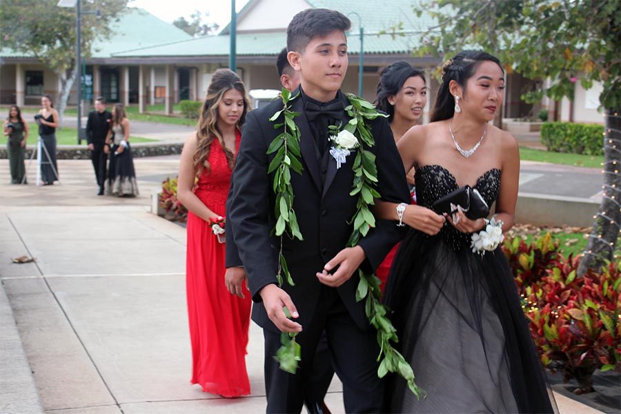 Sophomore+Ezekiel+Weber+and+junior+Kaelyn+Kato+stroll+from+the+valet+parking+area+to+check+in+for+Junior+Prom+with+Lexi+Pruse+and+Leeana+Kanemitsu+behind.+Kamehameha+Schools+Mauis+elementary+dining+hall+was+the+site+of+the+prom+for+the+Class+of+2019+on+April+14.+The+theme%3A+A+Little+South+of+Heaven.