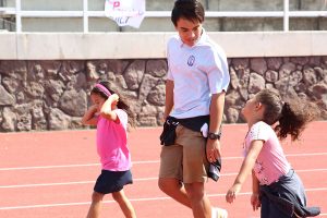 Senior Tai Kauhaa-Po accompanies two kindergarten buddies around the track at the Walk for Pauahi, Aaliyah Jaimes and Emalani Fabergas.