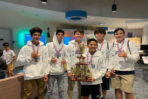 Isaiah Auweloa, Elijah Auweloa, Jonah Walker, Jayden Walker, and Laakea Goliz gather around Brenden Hanada, who is holding their championship trophy in the Hawaii Esports Arena. The KS Maui Rocket League team won first place in one of three gaming championships held January 25 at the Aloha Tower.