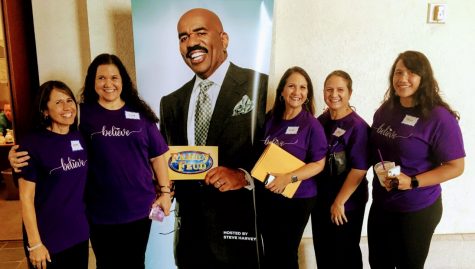 Coach Lemoe Tuas family poses next to a picture of Family Feud host Steve Harvey at the Family Feud auditions on Oʻahu. The Tuaʻs will be filming in California over Spring Break.