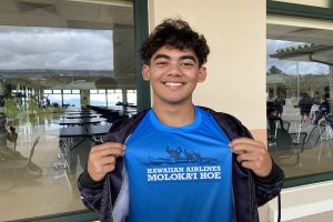 Junior Keolapono Keahi shows off his Molokaʻi Hoe t-shirt, showing his love for the sport of paddling.