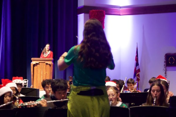 Band director Jess Eimen conducts the concert band, comprised of 53 students, while Mama Kahu Kanani Franco waits for her next cue as the night's emcee. -- photo courtesy of Jared Pendergraft