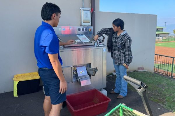 Seniors Jaren Merritt and Naupakapualahaole Olaitiman operate the machine during their ʻĀina and Sustainability class.